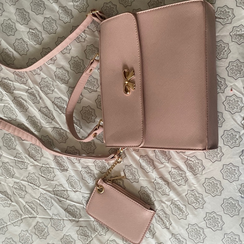 i’m selling a pink purse, with lots of space in it and a small wallet attached.